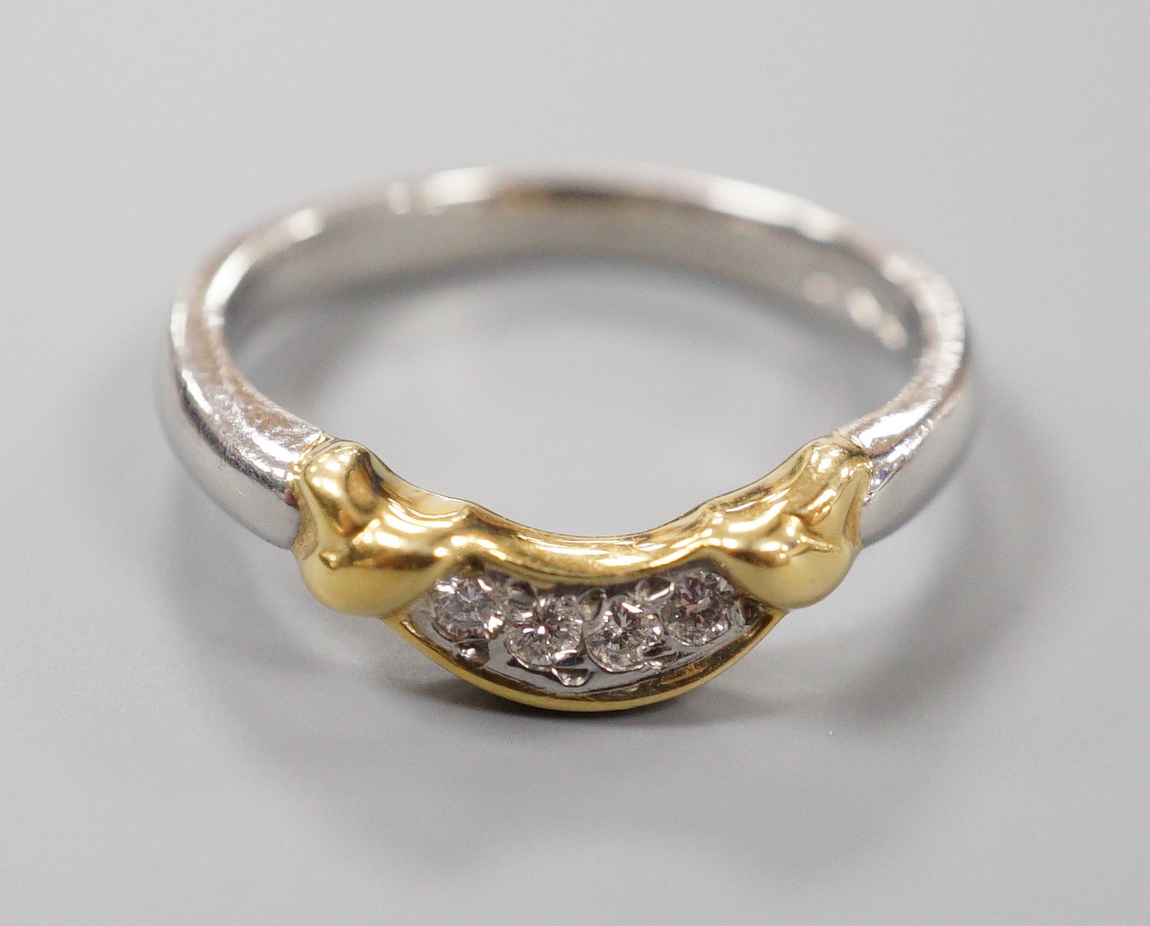 A modern platinum and yellow metal, four stone diamond set demi-lune ring, size N/O, gross weight 5.4 grams (part of a wedding set)